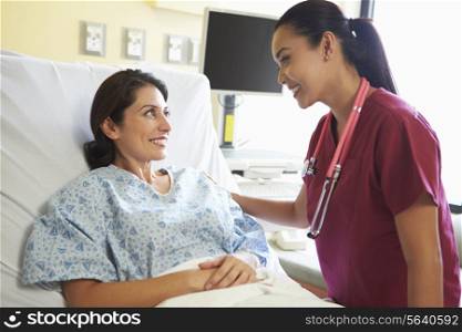 Nurse Talking To Female Patient In Hospital Room