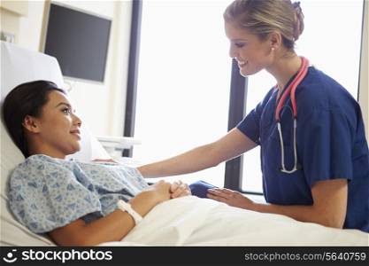 Nurse Talking To Female Patient On Ward