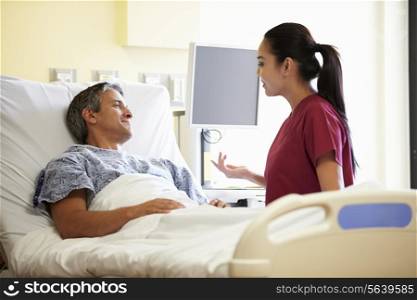 Nurse Talking To Male Patient In Hospital Room