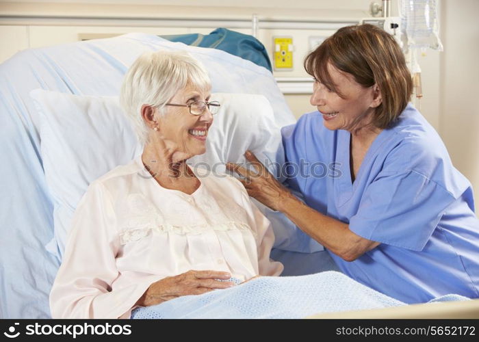 Nurse Talking To Senior Female Patient In Hospital Bed