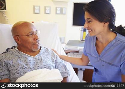 Nurse Talking To Senior Male Patient In Hospital Room