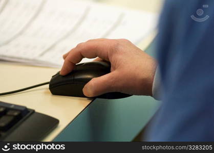 Nurse using mouse while filling out patient&acute;s electronic records.