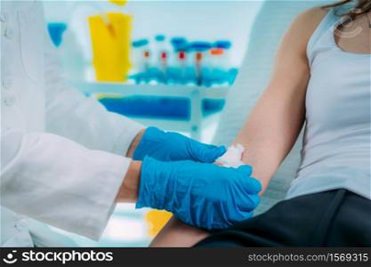 Nurse with protective mask drawing blood for laboratory analysis during coronavirus crisis