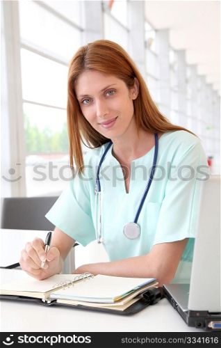 Nurse working on laptop computer in hospital
