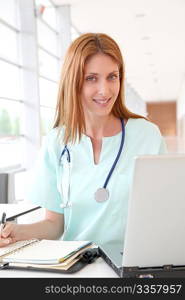 Nurse working on laptop computer in hospital