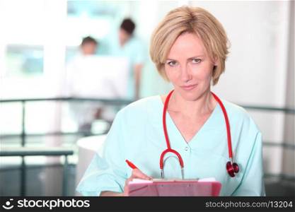 Nurse writing on clip-board