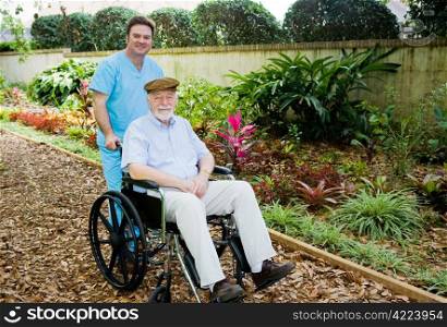 Nursing home orderly takes a senior man for a walk in the garden.