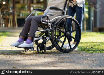 Nursing home. Young caregiver helping senior woman in wheelchair