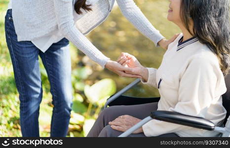 Nursing home. Young caregiver helping senior woman in wheelchair