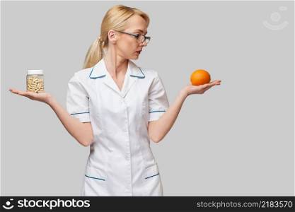 nutritionist doctor healthy lifestyle concept - holding fresh organic orange fruit and vitamin capsules.. nutritionist doctor healthy lifestyle concept - holding fresh organic orange fruit and vitamin capsules