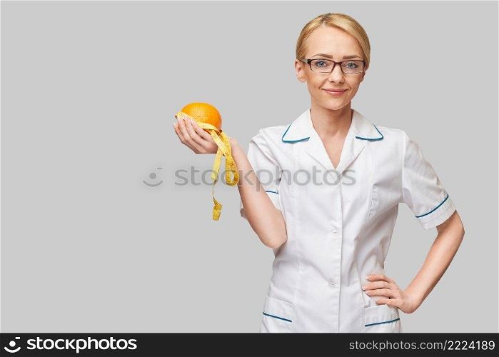 nutritionist doctor healthy lifestyle concept - holding orange fruit and measure tape.. nutritionist doctor healthy lifestyle concept - holding orange fruit and measure tape