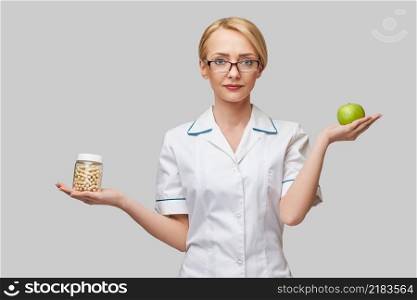 nutritionist doctor healthy lifestyle concept - holding organic fresh green apple and can of vitamin capsules.. nutritionist doctor healthy lifestyle concept - holding organic fresh green apple and can of vitamin capsules