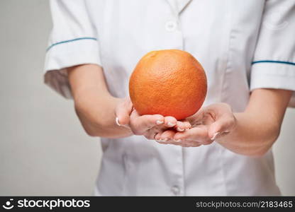 nutritionist doctor healthy lifestyle concept - holding organic grapefruit or orange fruit.. nutritionist doctor healthy lifestyle concept - holding organic grapefruit or orange fruit