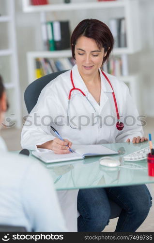 nutritionist doctor writing diet plan in office