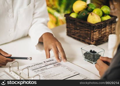 Nutritionist explaining nutrition facts label to a client, close-up. Nutrition Facts 