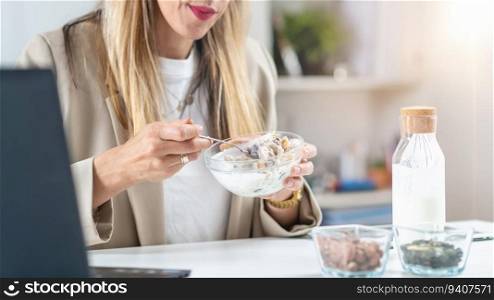 Nutritious meal at work. Woman indulges in a satisfying bowl of muesli and creamy yogurt, fueling her body with a balanced and energizing breakfast. Woman Enjoying Muesli and Yogurt at Work