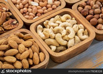 nuts abstract - cashew, pecan, hazelnut, Spanish peanut in wooden bowls