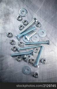Nuts and bolts on the table. On a gray background. High quality photo. Nuts and bolts on the table.