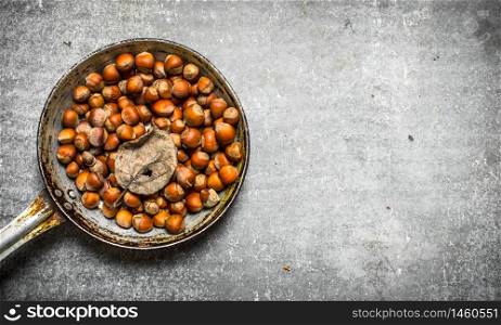Nuts in an old pan. On the stone table.. Nuts in an old pan.