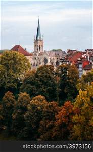 Nydeggkirche 14th century Protestant church with bronze reliefs and clock tower among colourful autumn tree in old town Bern - Switzerland