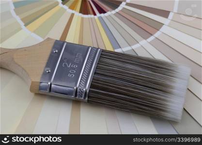 nylon paintbrush against radiating paint color swatches (pastel earth tones)