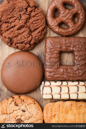 Oat and chocolate cookies selection on wooden board on stone kitchen background
