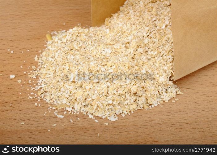 oat bran in a paper bag on a wooden background
