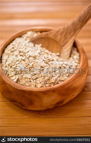 Oat flakes. Oat flakes with at wooden plate on wooden background
