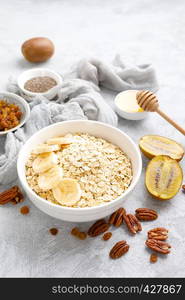 Oat flakes with fruits, nuts and honey in bowl