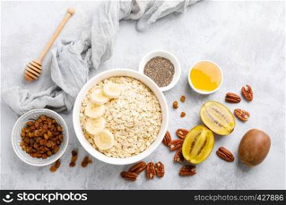 Oat flakes with fruits, nuts and honey in bowl