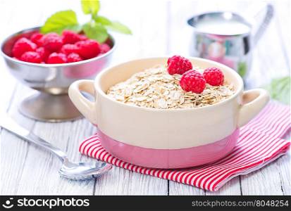 oat flakes with raspberry in bowl and on a table