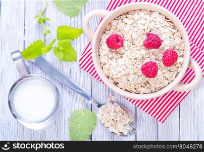 oat flakes with raspberry in bowl and on a table