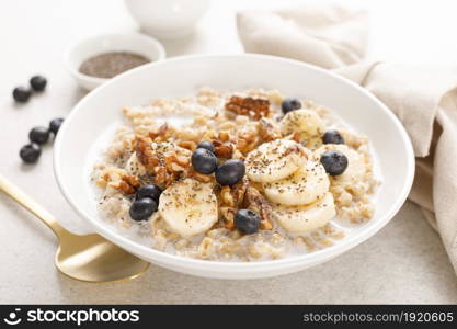 Oatmeal bowl. Oat porridge with banana, blueberry, walnut, chia seeds and almond milk for healthy breakfast or lunch. Healthy food, diet.