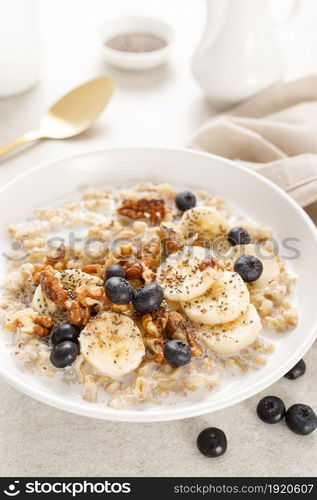 Oatmeal bowl. Oat porridge with banana, blueberry, walnut, chia seeds and almond milk for healthy breakfast or lunch. Healthy food, diet.