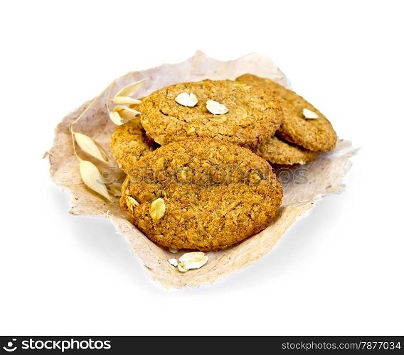 Oatmeal cookies with a stalk of oats on paper isolated on white background