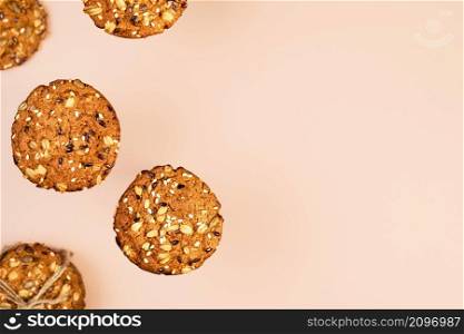 Oatmeal cookies with flax, sunflower and sesame seeds on nude color wallpaper with copy space for text. Healthy fitness food concept. Milk and homemade cookies for breakfast