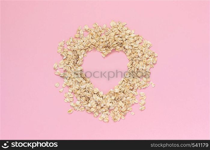 Oatmeal in shape of heart with empty space for text on pink background. Diet concept, Top view Copy space.. Oatmeal in shape of heart with empty space for text on pink background. Diet concept, Top view Copy space
