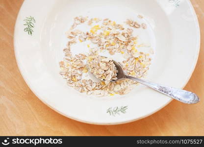 oatmeal in white bowl on orange napkin.. oatmeal in white bowl on orange napkin