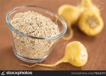 Oatmeal mixed with maca or Peruvian ginseng (lat. Lepidium meyenii), with fresh maca roots around (Selective Focus, Focus one third into the oatmeal). Oatmeal with Maca