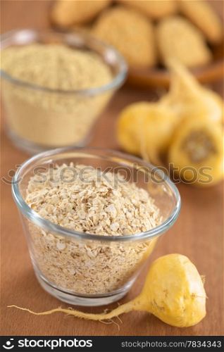 Oatmeal mixed with maca or Peruvian ginseng (lat. Lepidium meyenii), surrounded by fresh maca roots, maca powder and cookies made of maca (Selective Focus, Focus in the middle of the oatmeal and the front of the maca root beside it). Oatmeal with Maca