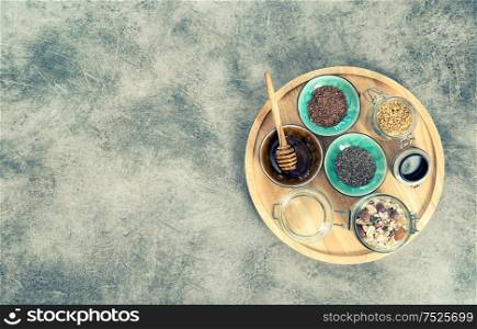 Oatmeal muesli breakfast with chia seeds, goji berries, linseed, honey. Vintage style toned photo