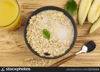 oatmeal porridge bowl with cup orange juice