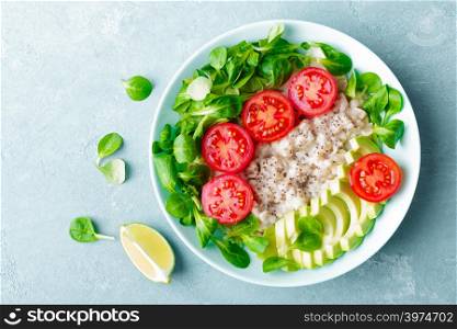 Oatmeal porridge with avocado and vegetable salad of fresh tomatoes and lettuce. Healthy dietary breakfast. Top view