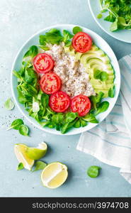 Oatmeal porridge with avocado and vegetable salad of fresh tomatoes and lettuce. Healthy dietary breakfast. Top view