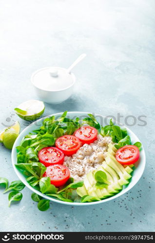 Oatmeal porridge with avocado and vegetable salad of fresh tomatoes and lettuce. Healthy dietary breakfast