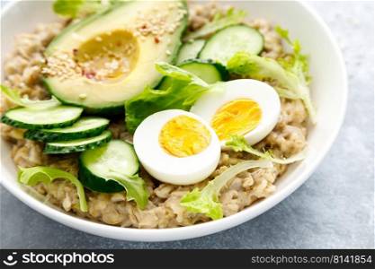 Oatmeal porridge with boiled egg, cucumber and avocado