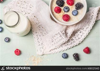 oatmeal porridge with milk and berries on kitchen towel, top view