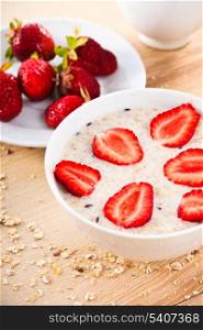 oatmeal porridge with strawberries on table