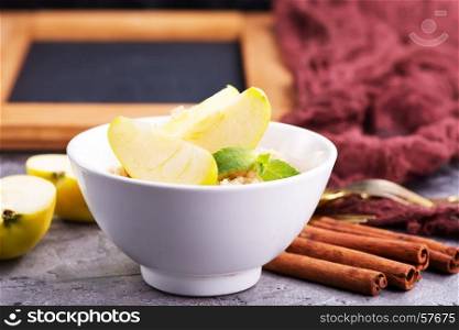 Oatmeal with fresh apples and cinnamon in the bowl