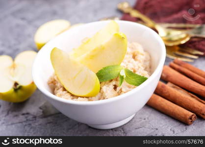 Oatmeal with fresh apples and cinnamon in the bowl